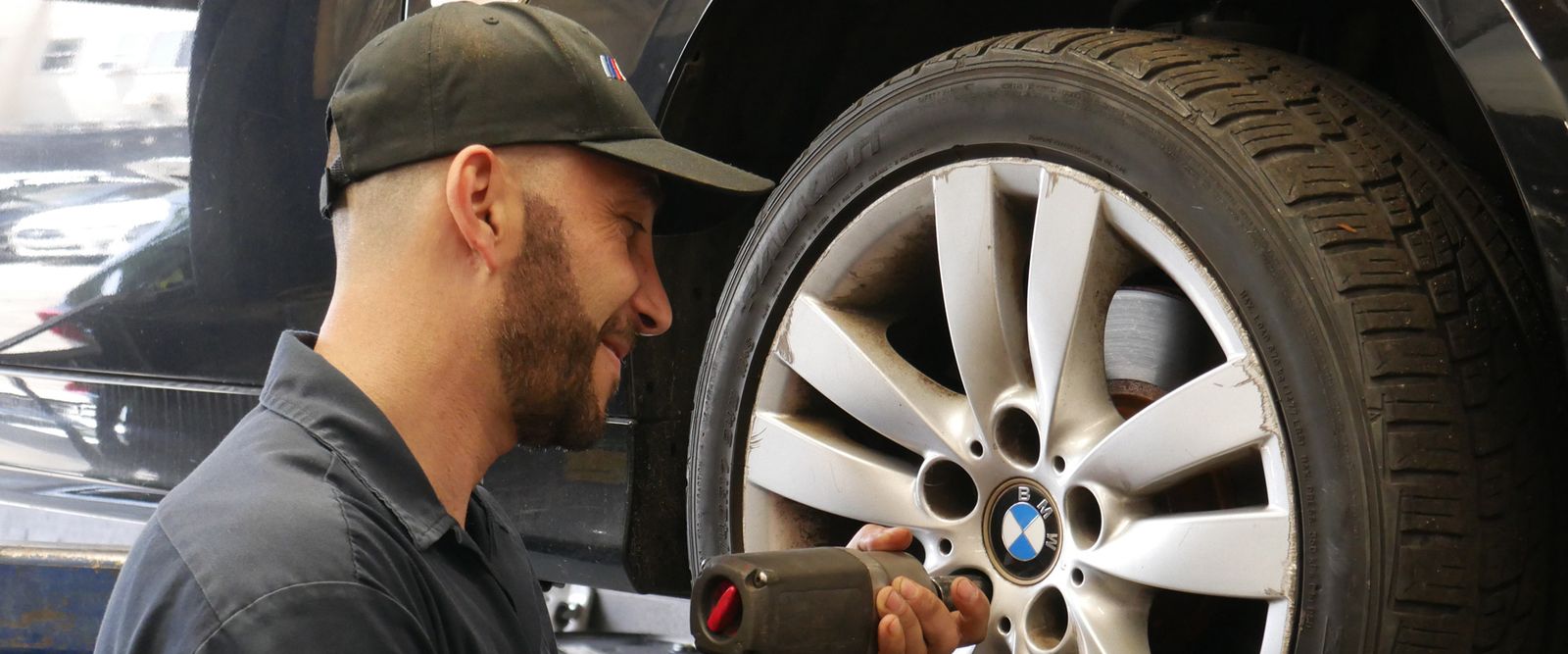 M Fast Auto mechanic torquing a wheel with an impact wrench